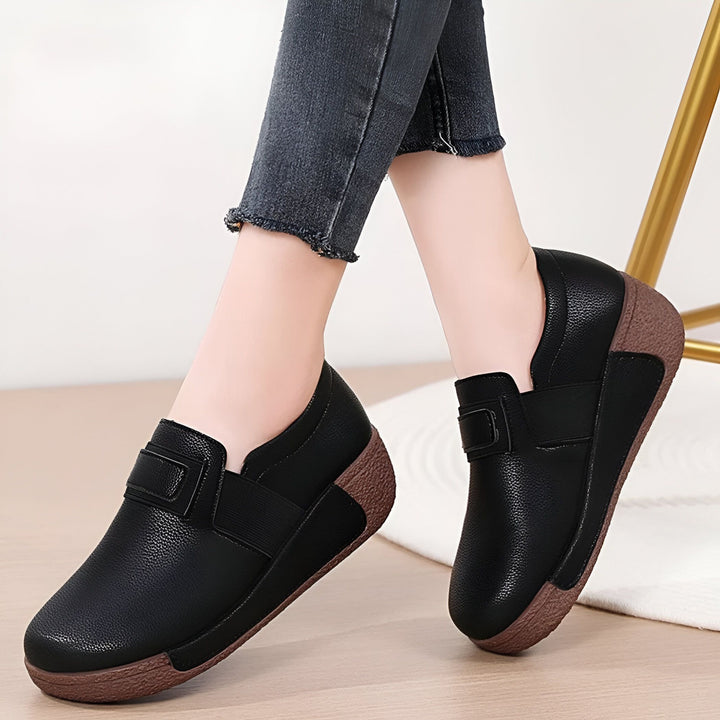 Gros plan sur des chaussures plates noires portées avec un jean foncé. Chaussures en cuir confortables avec une semelle compensée marron. Style décontracté et élégant., 45286646448309,45286646481077,45286646513845,45286646546613,45286646579381,45286646612149,45286646644917,45286646677685,45286646710453,45286646743221,45286646775989,45286646808757,45286646841525,45286646874293,45286646907061,45286646939829,45286646972597,45286647005365,45286647038133,45286647070901,45286647103669,45286647136437,4528