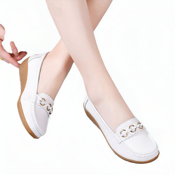 Gros plan sur des pieds portant des mocassins blancs élégants avec des ornements dorés. Chaussures confortables et tendance pour femme. Mode printemps-été., 45286797541557,45286797574325,45286797607093,45286797639861,45286797672629,45286797705397,45286797738165,45286797770933,45286797803701,45286797836469,45286797869237,45286797902005,45286797934773,45286797967541,45286798000309,45286798033077,45286798065845,45286798098613,45286798131381,45286798164149,45286798196917,45286798229685,45286798262453,452