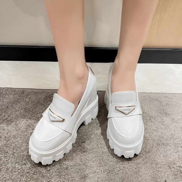 Gros plan sur des mocassins blancs à plateforme et semelle épaisse portés par une personne. Détail du logo "FASHION" doré sur la chaussure., 45286905938101,45286905970869,45286906003637,45286906036405,45286906069173,45286906101941,45286906134709,45286906167477,45286906200245,45286906233013,45286906265781,45286906298549