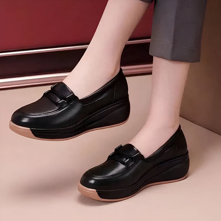 Gros plan sur une paire de mocassins noirs en cuir à semelles compensées couleur chair portés par une femme, style classique et confortable., 45286965838005,45286965870773,45286965903541,45286965936309,45286965969077,45286966001845,45286966034613,45286966067381,45286966100149,45286966132917,45286966165685,45286966198453,45286966231221,45286966263989,45286966296757,45286966329525,45286966362293,45286966395061