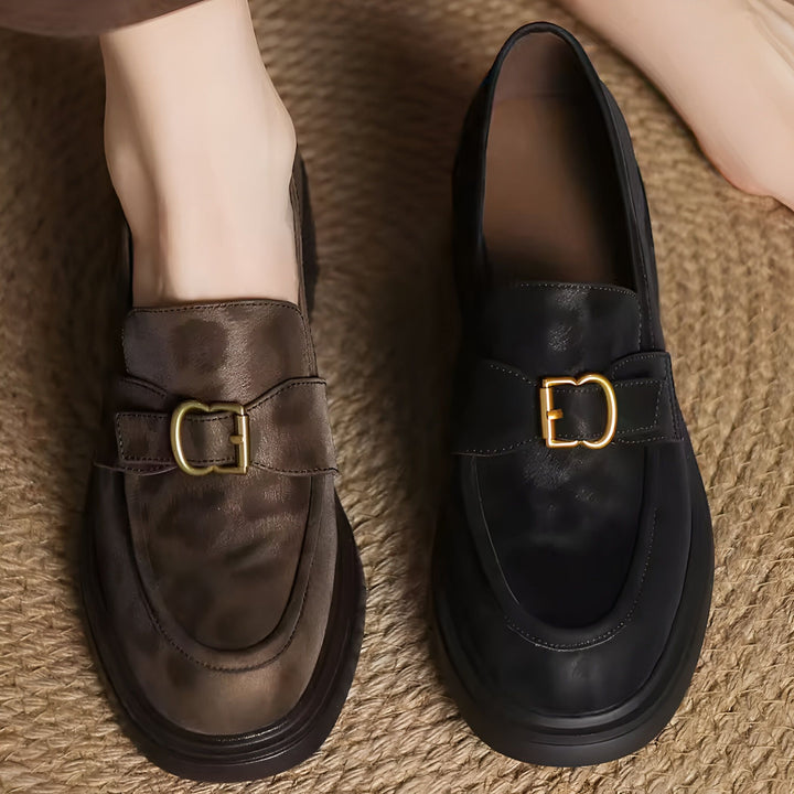 Mocassins pour femmes en cuir noir et marron, avec boucle dorée distinctive. Chaussures élégantes et confortables pour un look sophistiqué. Détail de la texture et de la qualité des matériaux., 45286621708469,45286621741237,45286621774005,45286621806773,45286621839541,45286621872309,45286621905077,45286621937845,45286621970613,45286622003381,45286622036149,45286622068917,45286622101685,45286622134453,45286622167221,45286622199989