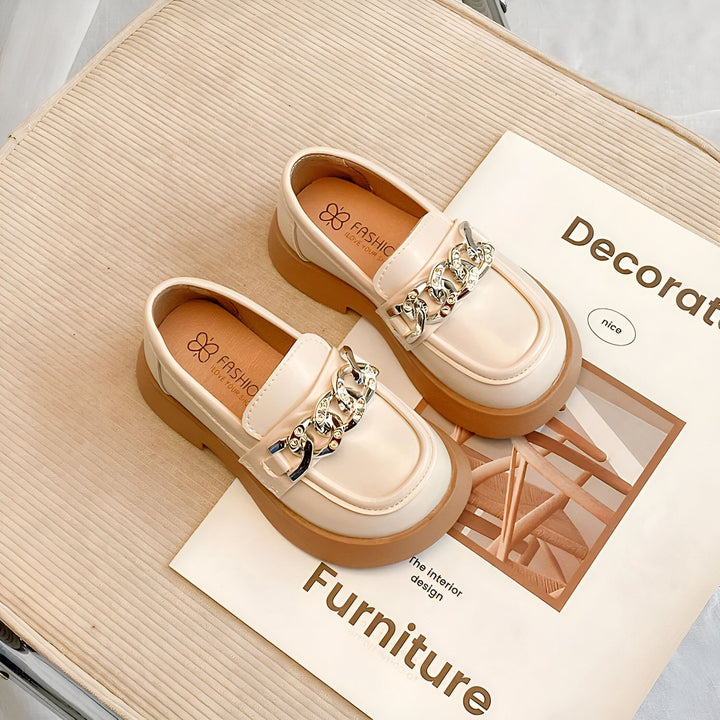 Paire de mocassins beige vernis pour enfants, avec une chaîne décorative argentée. Chaussures élégantes posées sur un magazine de décoration intérieure. Idéal pour un look chic et confortable., 45287036944565,45287036977333,45287037010101,45287037042869,45287037075637,45287037108405,45287037141173,45287037173941,45287037206709,45287037239477,45287037272245,45287037305013,45287037337781,45287037370549,45287037403317,45287037436085,45287037468853,45287037501621,45287037534389,45287037567157,4528703