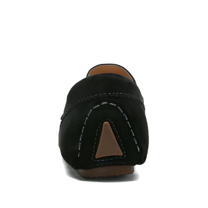 Vue arrière d'un mocassin noir en daim. Les détails comprennent une couture décorative en forme de U et un talon plat. Chaussure décontractée et confortable pour femme., 45286802653365,45286802686133,45286802718901,45286802751669,45286802784437,45286802817205,45286802849973