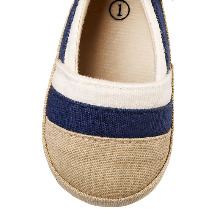 Gros plan sur une chaussure de bébé rayée beige, bleue et blanche. L'intérieur de la chaussure est beige avec le chiffre "1" en noir., 45286820937909,45286820970677,45286821003445,45286821036213,45286821068981,45286821101749