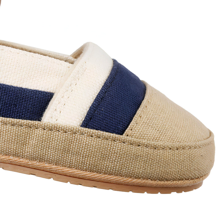 Gros plan d'une espadrille beige et bleu marine en toile. Chaussure d'été décontractée à rayures. Détail de la texture du tissu et de la semelle., 45286820937909,45286820970677,45286821003445,45286821036213,45286821068981,45286821101749