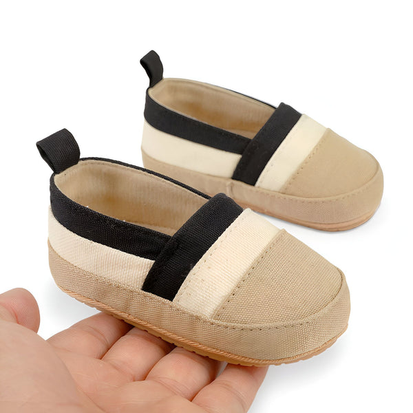 Chaussures de bébé souples à rayures beiges, blanches et noires, tenues dans une main. Chaussons pour nouveau-né confortables, style décontracté. Idéales pour les premiers pas., 45286820937909,45286820970677,45286821003445,45286821036213,45286821068981,45286821101749