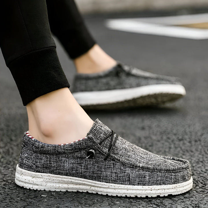 Homme portant des chaussures décontractées en toile grise à semelle blanche. Détail sur les lacets élastiques noirs et l'intérieur rayé. Style décontracté, confortable et moderne. Idéal pour le quotidien., 45286731415733,45286731448501,45286731481269,45286731514037,45286731546805,45286731579573,45286731612341,45286731645109,45286731677877,45286731710645,45286731743413,45286731776181,45286731808949,45286731841717,45286731874485,45286731907253,45286731940021,45286731972789,45286732005557,452867320