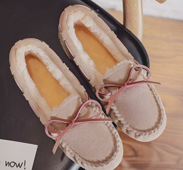 Deux mocassins beiges avec un nœud rose, doublés de fourrure blanche, reposant sur une surface sombre. Chaussures confortables et élégantes pour l'intérieur. Mode automne-hiver., 45286975275189,45286975307957,45286975340725,45286975373493,45286975406261,45286975439029,45286975471797,45286975504565,45286975537333,45286975570101,45286975602869,45286975635637,45286975668405,45286975701173,45286975733941,45286975766709,45286975799477,45286975832245,45286975865013,45286975897781,45286975930549,45286975963