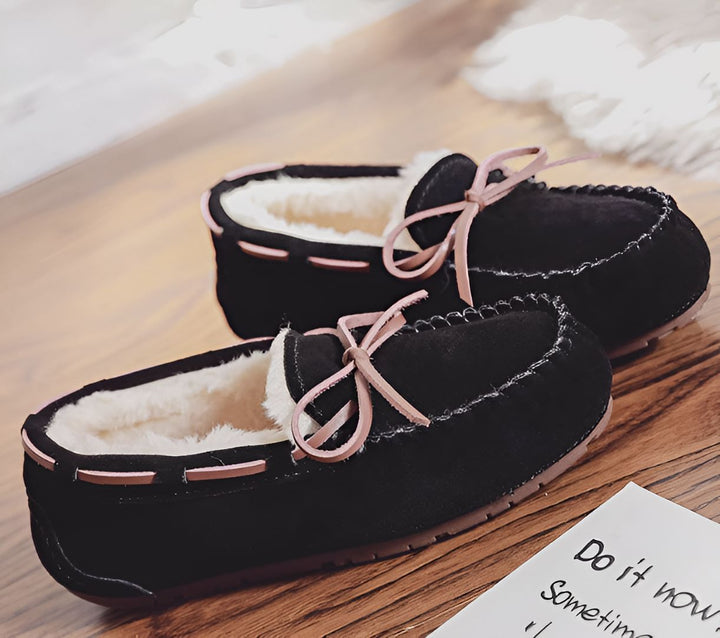 Mocassins d'intérieur noirs en daim avec doublure en fausse fourrure blanche et lacets roses, posés sur un plancher en bois. Chaussons confortables pour l'hiver, vus de près., 45286975275189,45286975307957,45286975340725,45286975373493,45286975406261,45286975439029,45286975471797,45286975504565,45286975537333,45286975570101,45286975602869,45286975635637,45286975668405,45286975701173,45286975733941,45286975766709,45286975799477,45286975832245,45286975865013,45286975897781,45286975930549,45286975963317,4