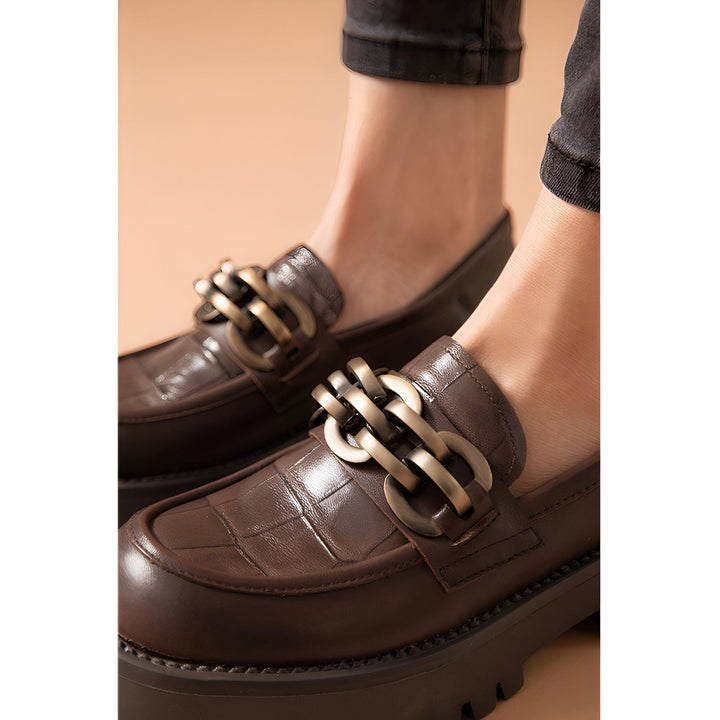 Mocassins marron foncé avec détail de chaîne dorée sur le dessus, portés avec un jean noir. Chaussures élégantes et confortables, parfaites pour un look décontracté chic., 45286863470773,45286863503541,45286863536309,45286863569077,45286863601845,45286863634613,45286863667381,45286863700149,45286863732917,45286863765685,45286863798453,45286863831221