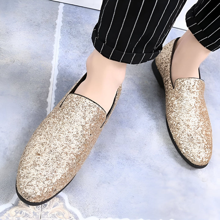 Gros plan de mocassins dorés à paillettes portés avec un pantalon rayé noir et blanc. Chaussures élégantes et originales pour une tenue de soirée., 45286638649525,45286638682293,45286638715061,45286638747829,45286638780597,45286638813365,45286638846133,45286638878901,45286638911669,45286638944437,45286638977205,45286639009973,45286639042741,45286639075509,45286639108277,45286639141045,45286639173813,45286639206581,45286639239349,45286639272117,45286639304885,45286639337653,45286639370421,4528663940