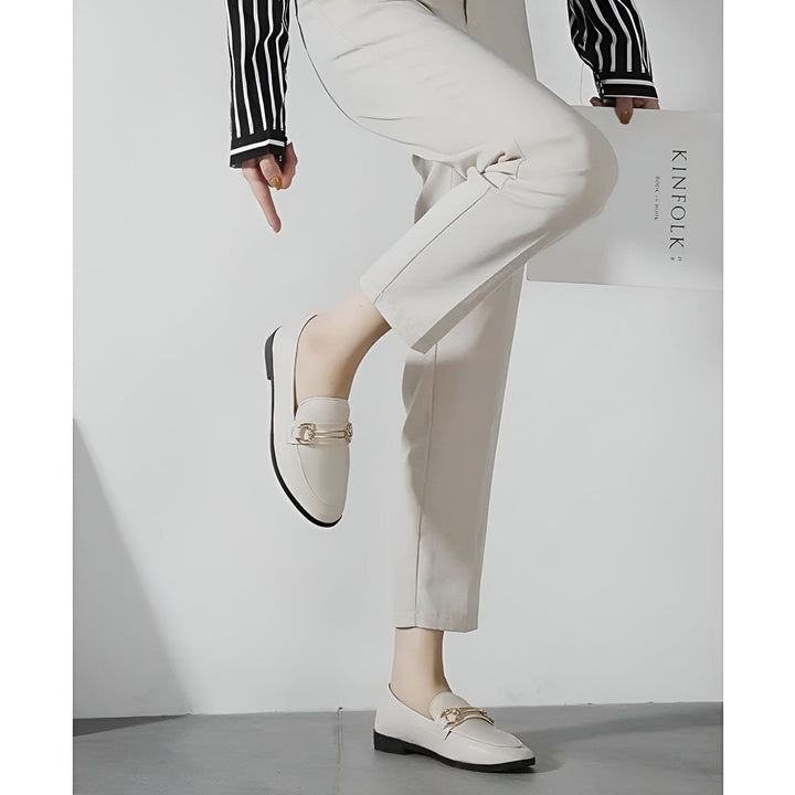 Mocassins crème élégants, portés avec un pantalon beige. Une main pointe vers la chaussure surélevée. Style décontracté chic, magazine "Kinfolk" visible. Mode féminine, confort et sophistication., 45286712311989,45286712344757,45286712377525,45286712410293,45286712443061,45286712475829,45286712508597,45286712541365,45286712574133,45286712606901,45286712639669,45286712672437,45286712705205,45286712737973,45286712770741,45286712803509,45286712836277,45286712869045,45286712901813,45286712934581,4528