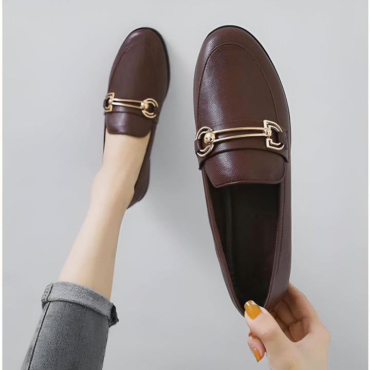 Mocassins marron pour femmes avec ornement doré, présentés avec une jambe et une main. Chaussures élégantes et confortables., 45286712311989,45286712344757,45286712377525,45286712410293,45286712443061,45286712475829,45286712508597,45286712541365,45286712574133,45286712606901,45286712639669,45286712672437,45286712705205,45286712737973,45286712770741,45286712803509,45286712836277,45286712869045,45286712901813,45286712934581,45286712967349,45286713000117,45286713032885,45286713065653,45286713098421,4528