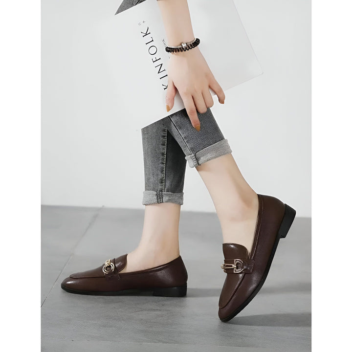 Gros plan sur une femme portant des mocassins marron à ornements dorés et un jean gris. Elle tient un magazine "Kinfolk" dans sa main. Mise en scène élégante et décontractée., 45286712311989,45286712344757,45286712377525,45286712410293,45286712443061,45286712475829,45286712508597,45286712541365,45286712574133,45286712606901,45286712639669,45286712672437,45286712705205,45286712737973,45286712770741,45286712803509,45286712836277,45286712869045,45286712901813,45286712934581,45286712967349,452867130001