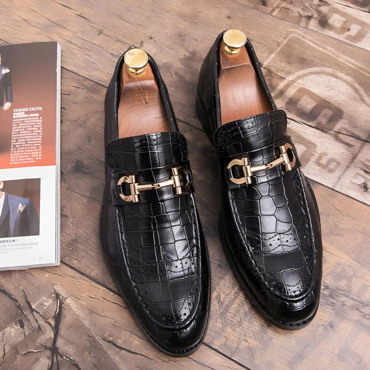 Gros plan de deux mocassins noirs en cuir avec motif crocodile et boucle dorée sur un plancher en bois, à côté d'un magazine. Chaussures élégantes et modernes., 45286694322357,45286694355125,45286694387893,45286694420661,45286694453429,45286694486197,45286694518965,45286694551733,45286694584501,45286694617269,45286694650037,45286694682805,45286694715573,45286694748341,45286694781109,45286694813877,45286694846645,45286694879413,45286694912181,45286694944949