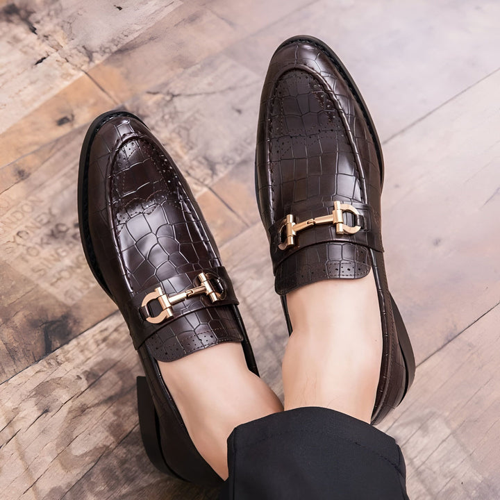 Gros plan de mocassins marron en cuir façon crocodile, avec boucle dorée, portés par un homme. Chaussures élégantes pour homme., 45286694322357,45286694355125,45286694387893,45286694420661,45286694453429,45286694486197,45286694518965,45286694551733,45286694584501,45286694617269,45286694650037,45286694682805,45286694715573,45286694748341,45286694781109,45286694813877,45286694846645,45286694879413,45286694912181,45286694944949