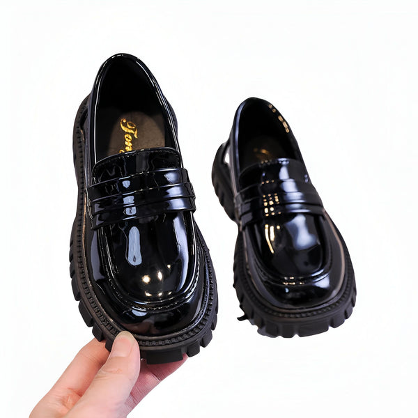 Photo de deux mocassins noirs vernis avec semelles épaisses. Une main tient l'un des mocassins., 45287038550197,45287038582965,45287038615733,45287038648501,45287038681269,45287038714037,45287038746805,45287038779573,45287038812341,45287038845109,45287038877877