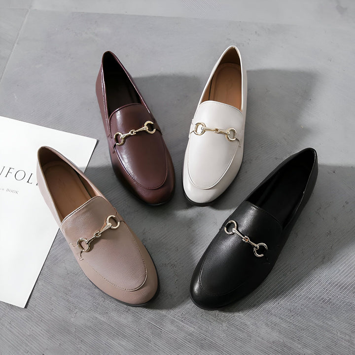 Quatre mocassins élégants pour femmes en cuir de différentes couleurs (marron, blanc, beige et noir) avec une boucle métallique dorée, disposés sur un fond gris. Chaussures plates confortables et à la mode., 45286855377077,45286855409845,45286855442613,45286855475381,45286855508149,45286855540917,45286855573685,45286855606453,45286855639221,45286855671989,45286855704757,45286855737525,45286855770293,45286855803061,45286855835829,45286855868597,45286855901365,45286855934133,45286855966901,4528685599