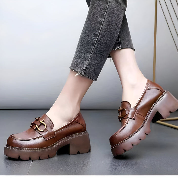 Gros plan de mocassins marron à talons portés avec un jean gris. Chaussures en cuir avec boucle dorée, style preppy ou tendance. Mode féminine, chaussures à plateforme., 45286850461877,45286850494645,45286850527413,45286850560181,45286850592949,45286850625717,45286850658485,45286850691253,45286850724021,45286850756789,45286850789557,45286850822325