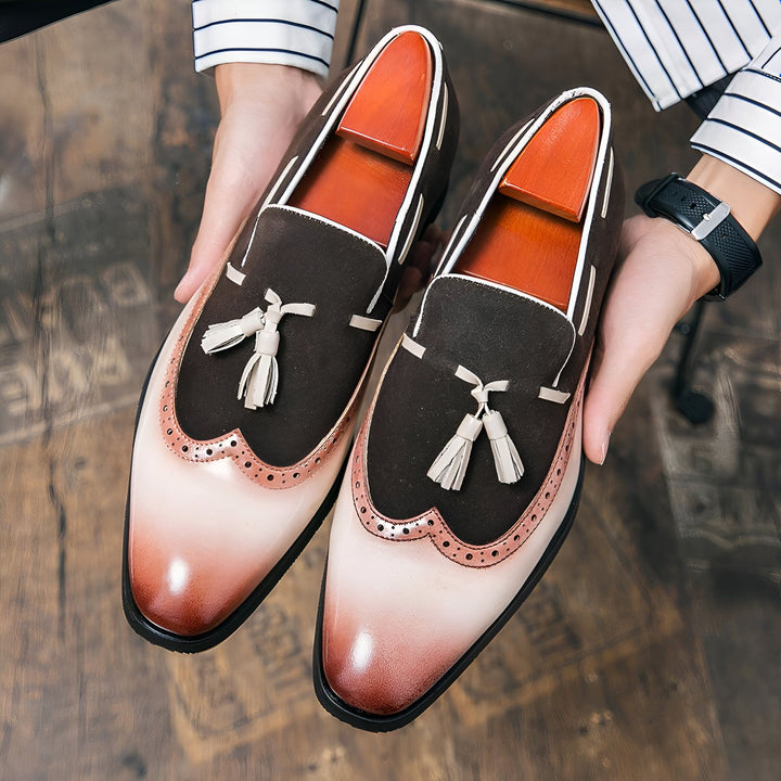 Un homme présente une paire de mocassins élégants en cuir marron et beige avec des détails de gland blanc. Les chaussures sont maintenues avec des embauchoirs en bois., 45287082328245,45287082361013,45287082393781,45287082426549,45287082459317,45287082492085,45287082524853,45287082557621,45287082590389,45287082623157,45287082655925,45287082688693,45287082721461,45287082754229,45287082786997,45287082819765,45287082852533,45287082885301,45287082918069,45287082950837,45287082983605,45287083016373