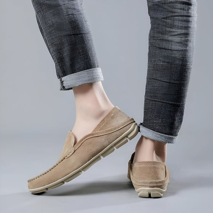 Gros plan de mocassins en cuir beige, portés avec un jean gris retroussé. Chaussures décontractées pour homme. Style et confort., 45286729711797,45286729744565,45286729777333,45286729810101,45286729842869,45286729875637,45286729908405,45286729941173,45286729973941,45286730006709,45286730039477,45286730072245,45286730105013,45286730137781,45286730170549,45286730203317,45286730236085,45286730268853,45286730301621,45286730334389