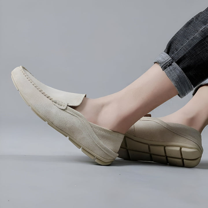 Un homme portant des mocassins en daim beige avec un jean décontracté. Chaussures confortables et élégantes pour un look moderne et décontracté. Détail de la couture visible., 45286729711797,45286729744565,45286729777333,45286729810101,45286729842869,45286729875637,45286729908405,45286729941173,45286729973941,45286730006709,45286730039477,45286730072245,45286730105013,45286730137781,45286730170549,45286730203317,45286730236085,45286730268853,45286730301621,45286730334389