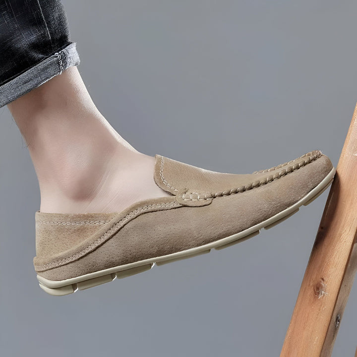 Mocassin en daim beige porté par un homme, avec un jean retroussé. Chaussure décontractée et confortable, idéale pour l'été. Détail de couture sur le dessus. Style élégant et moderne., 45286729711797,45286729744565,45286729777333,45286729810101,45286729842869,45286729875637,45286729908405,45286729941173,45286729973941,45286730006709,45286730039477,45286730072245,45286730105013,45286730137781,45286730170549,45286730203317,45286730236085,45286730268853,45286730301621,45286730334389