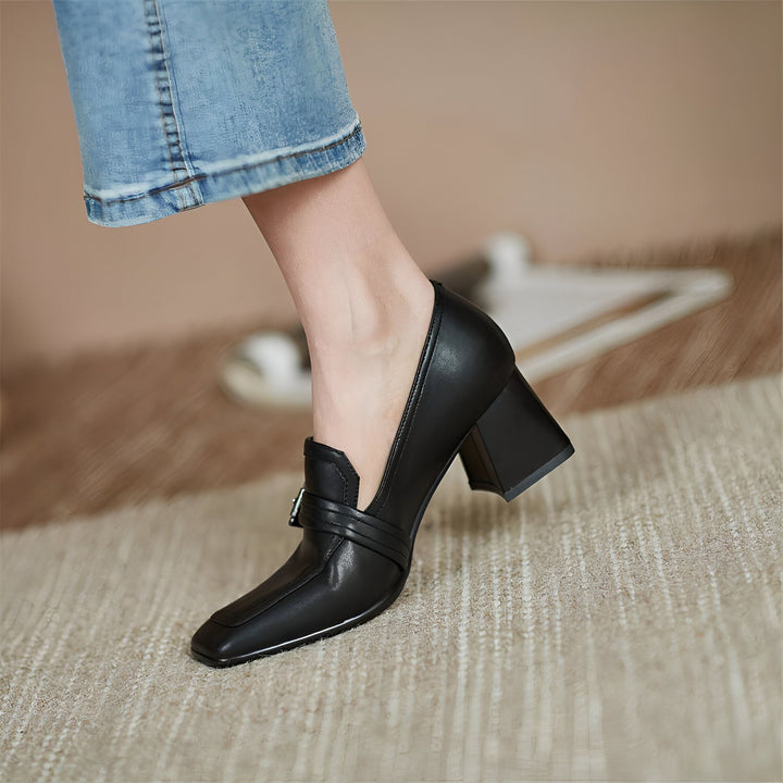 Gros plan d'une chaussure noire à talon bloc portée avec un jean. Chaussure en cuir élégante avec boucle décorative., 45287060340917,45287060373685,45287060406453,45287060439221,45287060471989,45287060504757,45287060537525,45287060570293,45287060603061,45287060635829,45287060668597,45287060701365