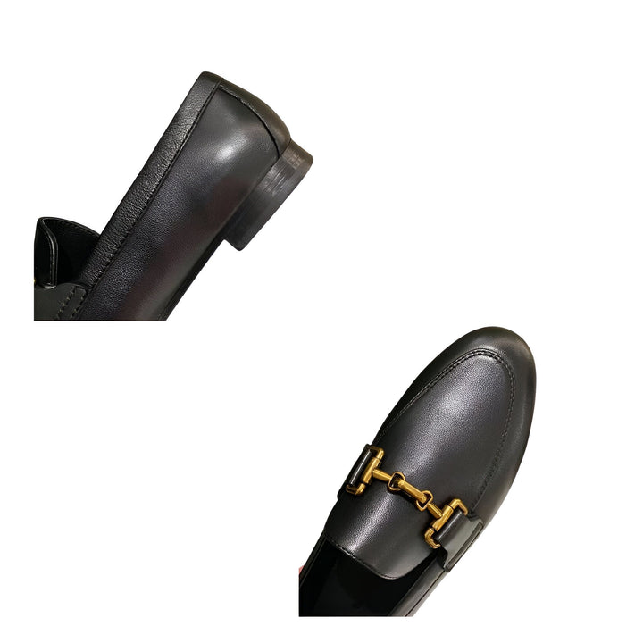 Vue rapprochée d'une paire de mocassins en cuir noir pour femme, ornés d'une boucle dorée. Détail du talon bas et de la forme élégante de la chaussure. Chaussures de mode, style classique., 45286728237237,45286728270005,45286728302773,45286728335541,45286728368309,45286728401077,45286728433845,45286728466613,45286728499381,45286728532149,45286728564917,45286728597685