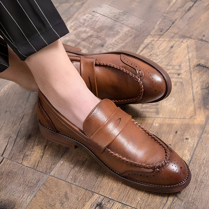Gros plan de mocassins en cuir marron pour hommes, avec un pantalon rayé noir et blanc en arrière-plan. Les chaussures sont posées sur un plancher en bois., 45286724501685,45286724534453,45286724567221,45286724599989,45286724632757,45286724665525,45286724698293,45286724731061,45286724763829,45286724796597,45286724829365,45286724862133,45286724894901,45286724927669,45286724960437,45286724993205,45286725025973,45286725058741,45286725091509,45286725124277