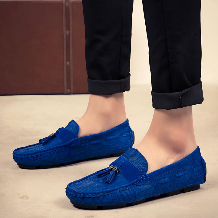 Homme portant des mocassins bleus en cuir avec pantalon noir. Détail : motif crocodile et glands décoratifs., 45287099465909,45287099498677,45287099531445,45287099564213,45287099596981,45287099629749,45287099662517,45287099695285,45287099728053,45287099760821,45287099793589,45287099826357,45287099859125,45287099891893,45287099924661,45287099957429,45287099990197,45287100022965,45287100055733,45287100088501,45287100121269,45287100154037,45287100186805,45287100219573
