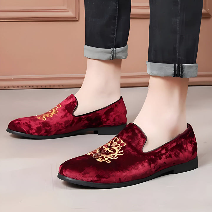 Gros plan sur des mocassins en velours bordeaux avec broderie dorée portés avec un jean noir. Chaussures élégantes pour hommes., 45286640091317,45286640124085,45286640156853,45286640189621,45286640222389,45286640255157,45286640287925,45286640320693,45286640353461,45286640386229,45286640418997,45286640451765,45286640484533,45286640517301,45286640550069,45286640582837,45286640615605,45286640648373,45286640681141,45286640713909,45286640746677,45286640779445,45286640812213,45286640844981,45286640877749,45