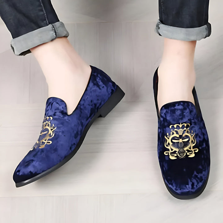 Homme portant des mocassins en velours bleu marine avec motifs dorés. Chaussures élégantes pour une occasion spéciale. Mode masculine., 45286640091317,45286640124085,45286640156853,45286640189621,45286640222389,45286640255157,45286640287925,45286640320693,45286640353461,45286640386229,45286640418997,45286640451765,45286640484533,45286640517301,45286640550069,45286640582837,45286640615605,45286640648373,45286640681141,45286640713909,45286640746677,45286640779445,45286640812213,45286640844981,4528664087