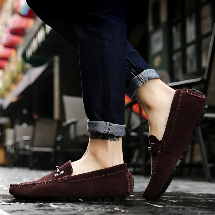 Gros plan sur des mocassins en daim bordeaux portés avec un jean foncé. Chaussures élégantes pour hommes, vêtement décontracté., 45286661095605,45286661128373,45286661161141,45286661193909,45286661226677,45286661259445,45286661292213,45286661324981,45286661357749,45286661390517,45286661423285,45286661456053,45286661488821,45286661521589,45286661554357,45286661587125,45286661619893,45286661652661,45286661685429,45286661718197,45286661750965,45286661783733,45286661816501,45286661849269,45286661914805