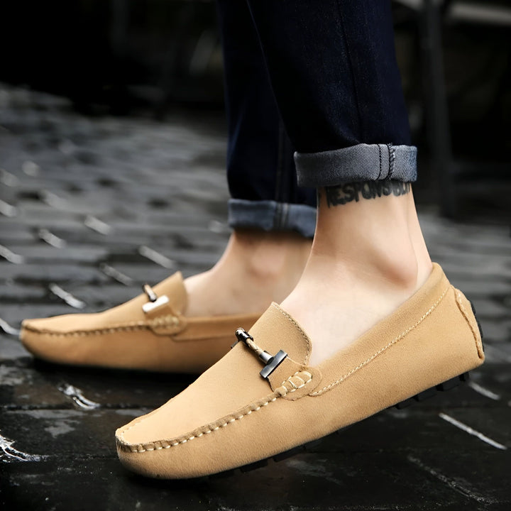 Mocassins beiges en daim pour homme, portés avec un jean bleu. Détail : ornement métallique sur le dessus. Style décontracté et élégant., 45286661095605,45286661128373,45286661161141,45286661193909,45286661226677,45286661259445,45286661292213,45286661324981,45286661357749,45286661390517,45286661423285,45286661456053,45286661488821,45286661521589,45286661554357,45286661587125,45286661619893,45286661652661,45286661685429,45286661718197,45286661750965,45286661783733,45286661816501,45286661849269,45286