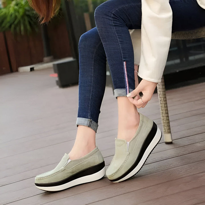Gros plan d'une femme assise, portant des chaussures plates compensées vert olive et un jean bleu marine. Son pantalon est retroussé, révélant une rayure rouge et bleue., 45286894141621,45286894174389,45286894207157,45286894239925,45286894272693,45286894305461,45286894338229,45286894370997,45286894403765,45286894436533,45286894469301,45286894502069,45286894534837,45286894567605,45286894600373,45286894633141,45286894665909,45286894698677,45286894731445,45286894764213,45286894796981,45286894829749,45286