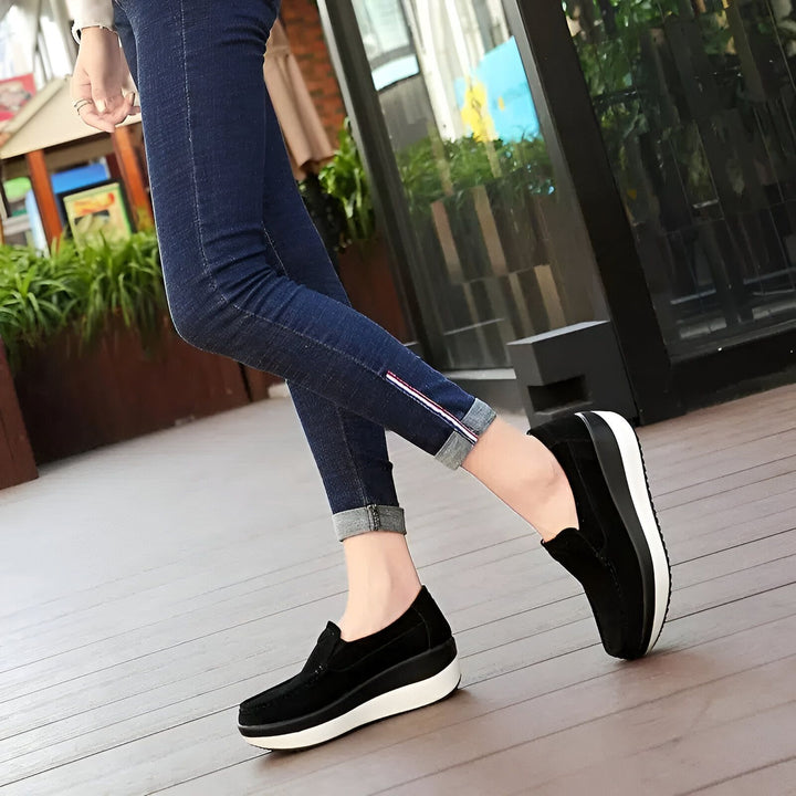 Gros plan sur une femme portant des mocassins compensés noirs et un jean slim bleu foncé avec un ourlet retroussé. Chaussures confortables et élégantes pour une tenue décontractée., 45286894141621,45286894174389,45286894207157,45286894239925,45286894272693,45286894305461,45286894338229,45286894370997,45286894403765,45286894436533,45286894469301,45286894502069,45286894534837,45286894567605,45286894600373,45286894633141,45286894665909,45286894698677,45286894731445,45286894764213,45286894796981,452868