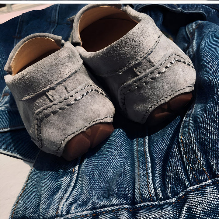 Une paire de mocassins en daim gris pour bébé sur un jean bleu. Les chaussures ont des semelles marron et des coutures décoratives apparentes., 45286973505717,45286973538485,45286973571253,45286973604021,45286973636789,45286973669557,45286973702325,45286973735093,45286973767861,45286973800629,45286973833397,45286973866165,45286973898933,45286973931701,45286973964469,45286973997237,45286974030005,45286974062773,45286974095541,45286974128309,45286974161077,45286974193845,45286974226613,45286974259381,452