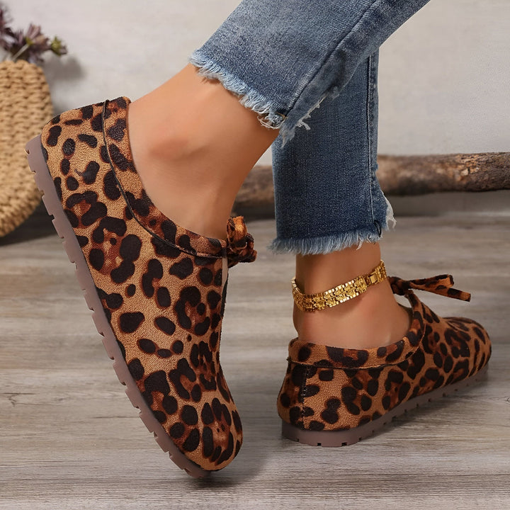 Gros plan de chaussures plates à motifs léopard portées avec un jean et une chaîne de cheville dorée. Chaussures décontractées confortables et tendance., 45286647955637,45286647988405,45286648021173,45286648053941,45286648086709,45286648119477,45286648152245,45286648185013,45286648217781