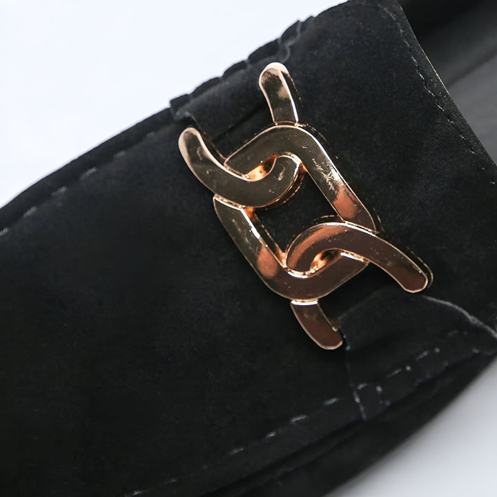 Gros plan d'un mocassin noir en daim avec une boucle dorée décorative en forme de chaîne. Élégance et confort pour un style raffiné. Mode masculine, chaussures de luxe, détails soignés., 45286663127221,45286663159989,45286663192757,45286663225525,45286663258293,45286663291061,45286663323829,45286663356597,45286663389365,45286663422133,45286663454901,45286663487669,45286663520437,45286663553205,45286663585973,45286663618741,45286663651509,45286663684277,45286663717045,45286663749813,45286663782581,