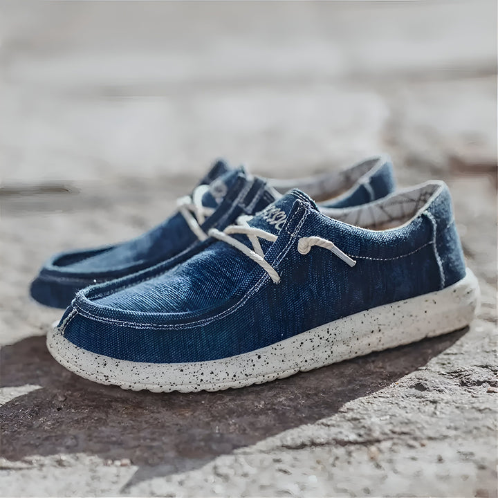 Deux chaussures décontractées en toile bleue avec lacets blancs, semelle blanche mouchetée, posées sur une surface texturée grise. Chaussures confortables et élégantes pour le quotidien., 45286669549749,45286669582517,45286669615285,45286669648053,45286669680821,45286669713589,45286669746357,45286669779125,45286669811893,45286669844661,45286669877429,45286669910197,45286669942965,45286669975733,45286670008501,45286670041269,45286670074037,45286670106805,45286670139573,45286670172341,45286670205109,