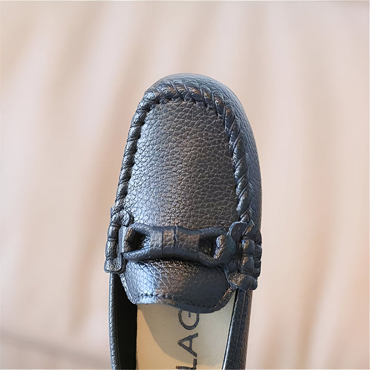 Gros plan sur un mocassin noir en cuir avec nœud décoratif. Chaussure élégante et confortable pour enfant. Détail de la texture du cuir et des finitions soignées., 45287045103797,45287045136565,45287045169333,45287045202101,45287045234869,45287045267637,45287045300405,45287045333173,45287045365941,45287045398709,45287045431477,45287045464245,45287045497013,45287045529781,45287045562549,45287045595317,45287045628085,45287045660853,45287045693621,45287045726389,45287045759157,45287045791925,4528704582