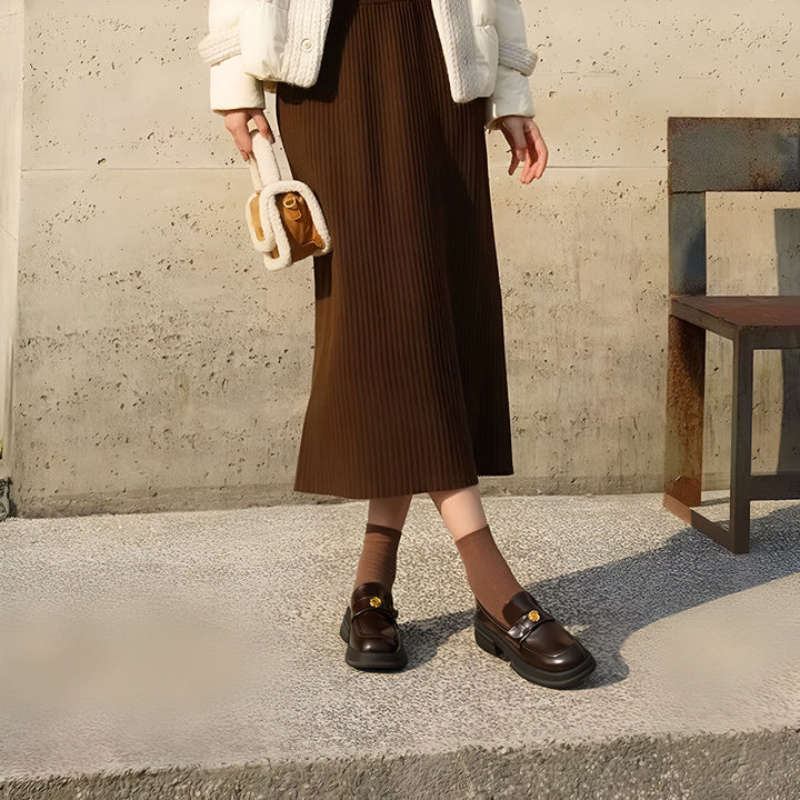 Image d'une femme portant une jupe marron plissée, un blouson blanc, des mocassins noirs avec chaussettes assorties, et un petit sac à main beige et marron. Style automnal décontracté., 45286630490293,45286630523061,45286630555829,45286630588597,45286630621365,45286630654133,45286630686901,45286630719669,45286630752437,45286630785205