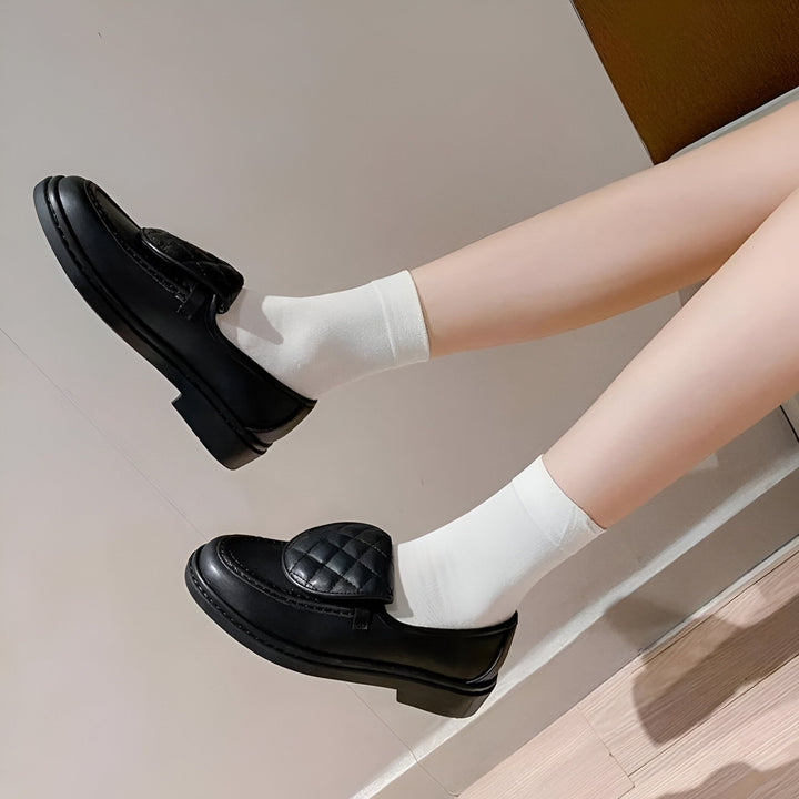 Gros plan sur une paire de mocassins noirs portés avec des chaussettes blanches. Les chaussures ont un motif matelassé sur le dessus. Style preppy chic. Mode féminine., 45286707888309,45286707921077,45286707953845,45286707986613,45286708019381,45286708052149,45286708084917,45286708117685,45286708150453,45286708183221,45286708215989,45286708248757,45286708281525,45286708314293