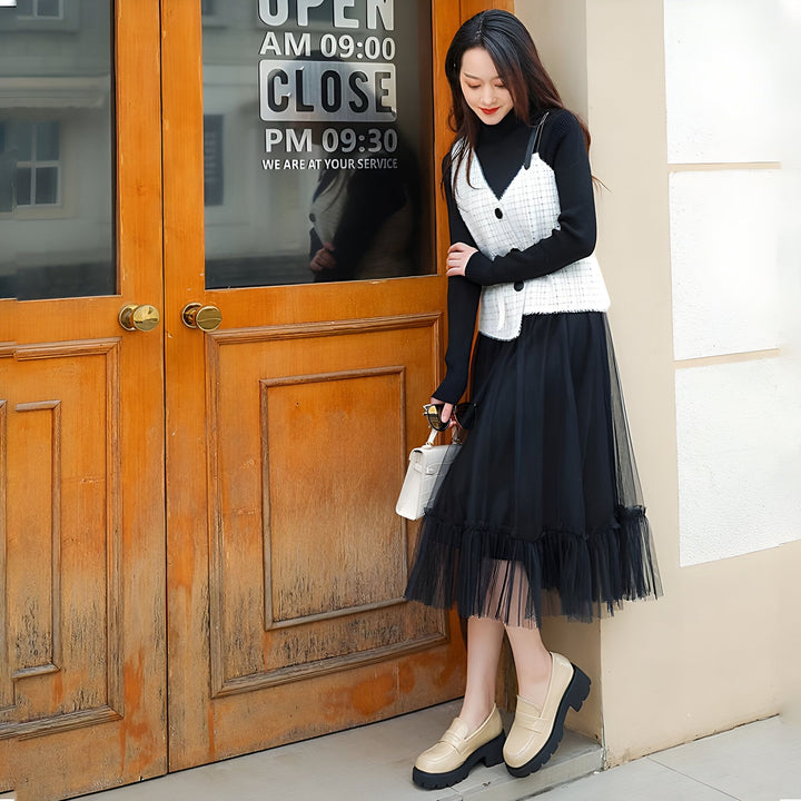 Jeune femme asiatique posant devant une porte en bois. Elle porte un col roulé noir, une jupe longue en tulle noir, un gilet blanc à carreaux et des mocassins beiges à plateforme. Elle tient un sac à main blanc., 45286916948149,45286916980917,45286917013685,45286917046453,45286917079221,45286917111989,45286917144757,45286917177525,45286917210293,45286917243061,45286917275829,45286917308597,45286917341365,45286917374133,45286917406901,45286917439669,45286917472437,45286917505205,45286917537973,45286917