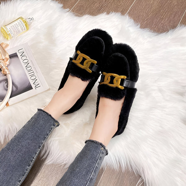 Gros plan sur des chaussons noirs en fausse fourrure avec détails dorés et chaîne. Portés par une personne en jean, sur un tapis blanc moelleux. Un parfum et un magazine sont visibles en arrière-plan. Chaussons confortables et stylés., 45286986842293,45286986875061,45286986907829,45286986940597,45286986973365,45286987006133,45286987038901,45286987071669,45286987104437,45286987137205,45286987169973,45286987202741,45286987235509,45286987268277,45286987301045,45286987333813,45286987366581,4528698739934