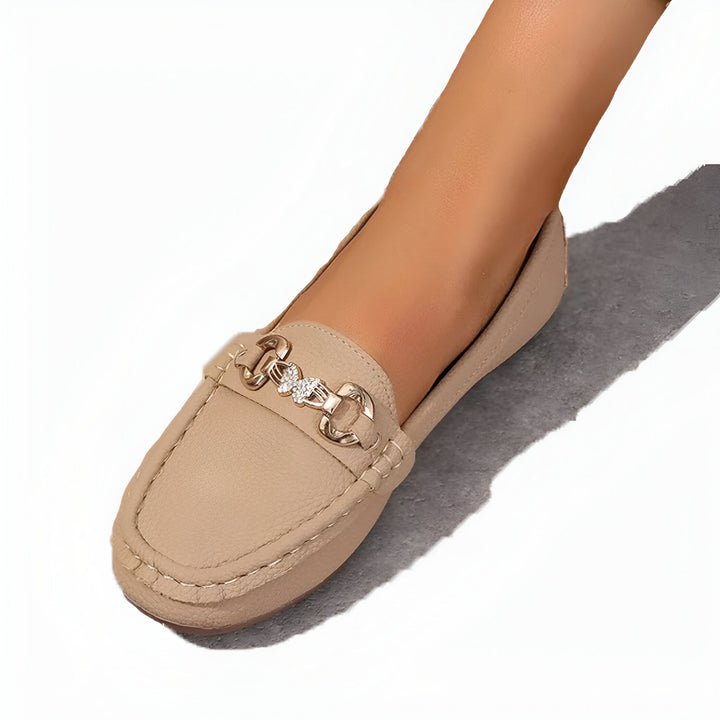 Mocassin beige pour femme avec ornement doré orné de strass, porté sur un pied. Chaussure élégante et confortable, idéale pour un look décontracté chic. Mode féminine., 45286627999925,45286628032693,45286628065461,45286628098229,45286628130997,45286628163765,45286628196533,45286628229301,45286628262069,45286628294837,45286628327605,45286628360373,45286628393141,45286628425909,45286628458677,45286628491445,45286628524213,45286628556981,45286628589749,45286628622517,45286628655285,45286628688053,45