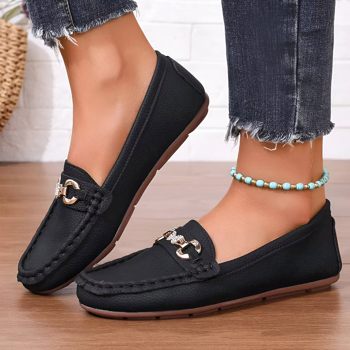 Mocassins noirs pour femmes avec détails dorés, portés avec un jean et une cheville ornée d'une chaîne de perles turquoise. Chaussures élégantes et confortables sur un sol en bois., 45286627999925,45286628032693,45286628065461,45286628098229,45286628130997,45286628163765,45286628196533,45286628229301,45286628262069,45286628294837,45286628327605,45286628360373,45286628393141,45286628425909,45286628458677,45286628491445,45286628524213,45286628556981,45286628589749,45286628622517,45286628655285,452866