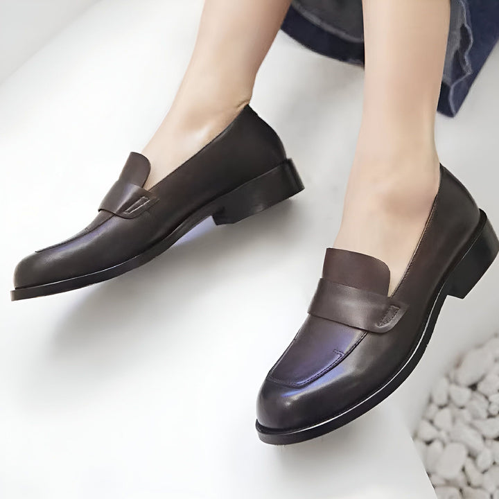 Gros plan des pieds d'une femme portant des mocassins en cuir marron foncé avec un talon bas., 45286620168373,45286620201141,45286620233909,45286620266677,45286620299445,45286620332213,45286620364981,45286620397749,45286620430517,45286620463285,45286620496053,45286620528821,45286620561589,45286620594357,45286620627125,45286620659893,45286620692661,45286620725429,45286620758197,45286620790965