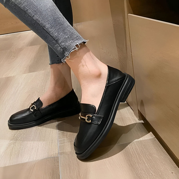 Gros plan sur des mocassins noirs en cuir portés avec un jean gris. Les chaussures ont une boucle dorée décorative sur le dessus., 45286721323189,45286721355957,45286721388725,45286721421493,45286721454261,45286721487029,45286721519797,45286721552565,45286721585333,45286721618101,45286721650869,45286721683637,45286721716405,45286721749173,45286721781941,45286721814709,45286721847477,45286721880245,45286721913013,45286721945781,45286721978549,45286722011317,45286722044085,45286722076853,45286722109621,4